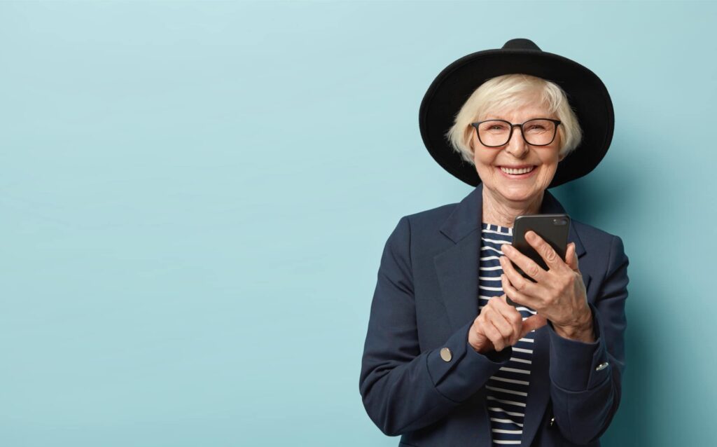 cheerful-female-pensioner-learns-how-use-smartphone-types-notification-1.jpg - Robbins Media